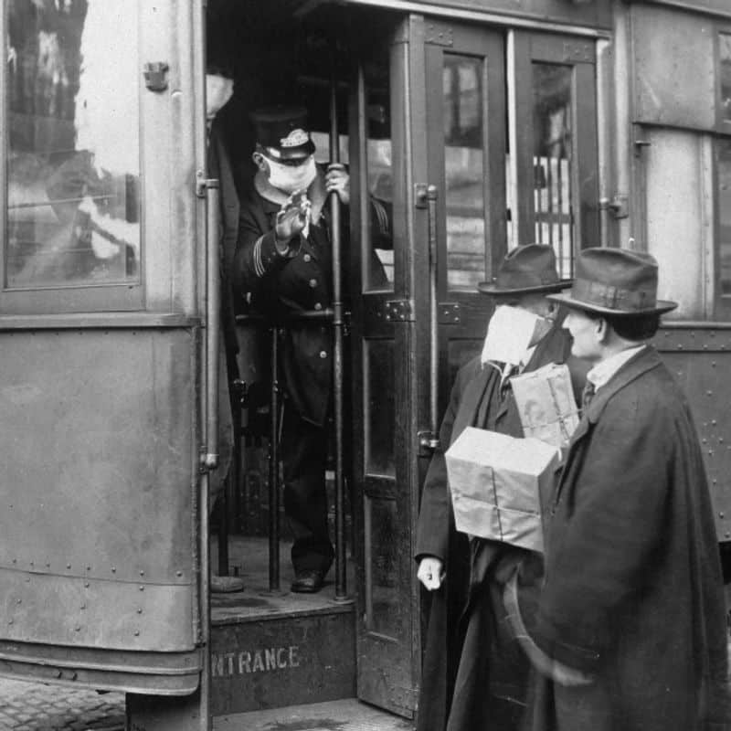 یک مسئول ماشین های خیابانی و مسافر در سیاتل که در طول همه گیری های 1918 ماسک هایی را می پوشیدند